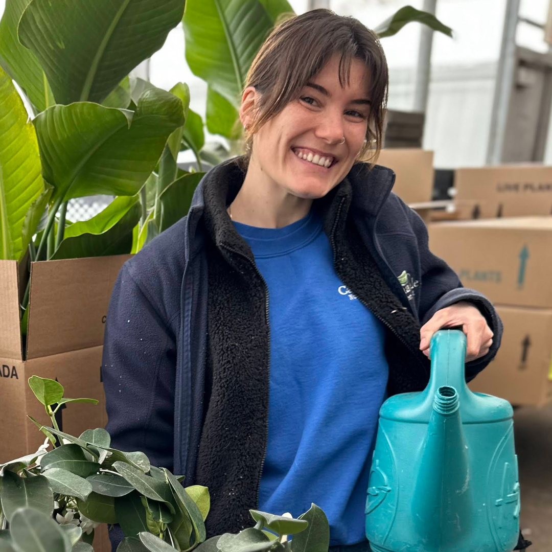 A staff member holding a watering can